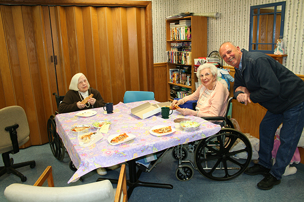 Residents enjoying a pizza lunch with family