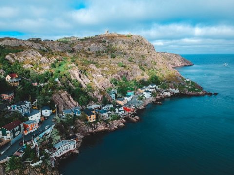 Houses on a mountain near a body of land during the day