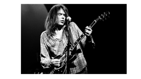 Man singing into microphone and playing guitar