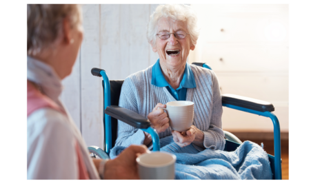 women sitting in wheelchair laughing 