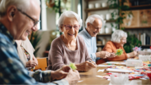 Woman and two men smiling and making crafts